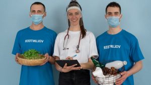 Three volunteers promoting eco-friendly practices with plants and recycling materials.